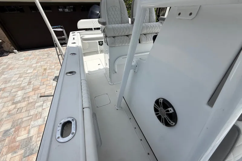 Slide: The Image of 1995 Intrepid 323 Open boat interior with seating and speaker, parked on a paved surface. - 56