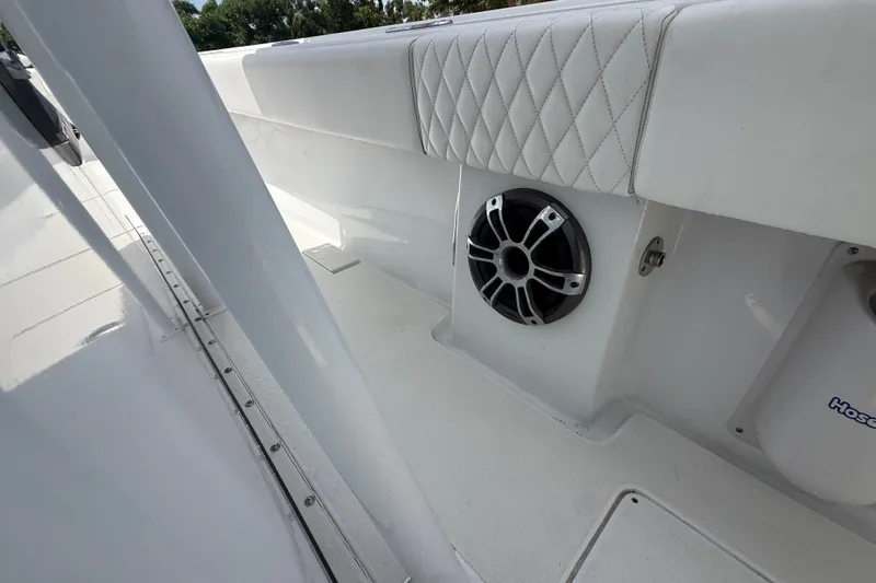 Slide: The Image of Interior view of a 1995 Intrepid 323 Open boat, featuring white upholstery and a speaker. - 27