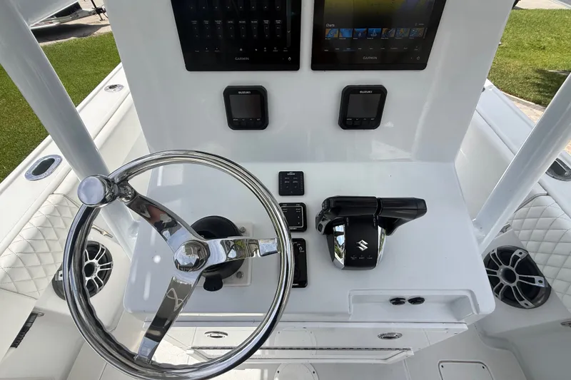 Slide: The Image of 1995 Intrepid 323 Open boat helm with steering wheel, controls, and Garmin displays. - 21