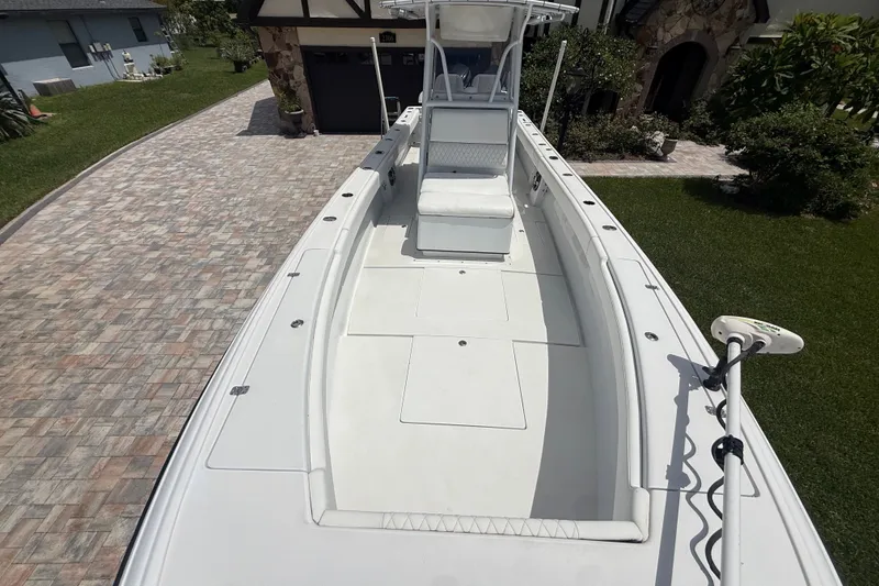 Slide: The Image of 1995 Intrepid 323 Open boat on driveway, showcasing spacious deck and seating. - 47