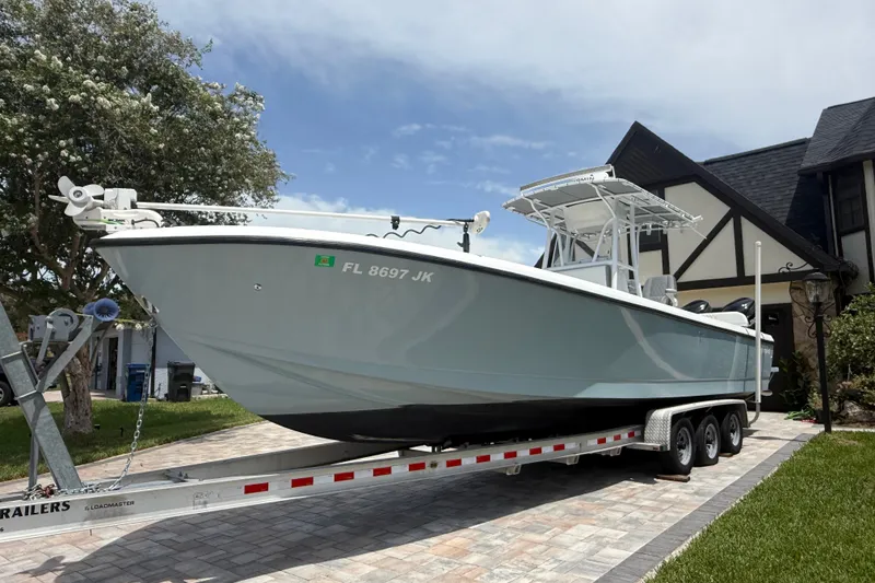 Slide: The Image of 1995 Intrepid 323 Open boat on trailer, parked in driveway near house. - 72