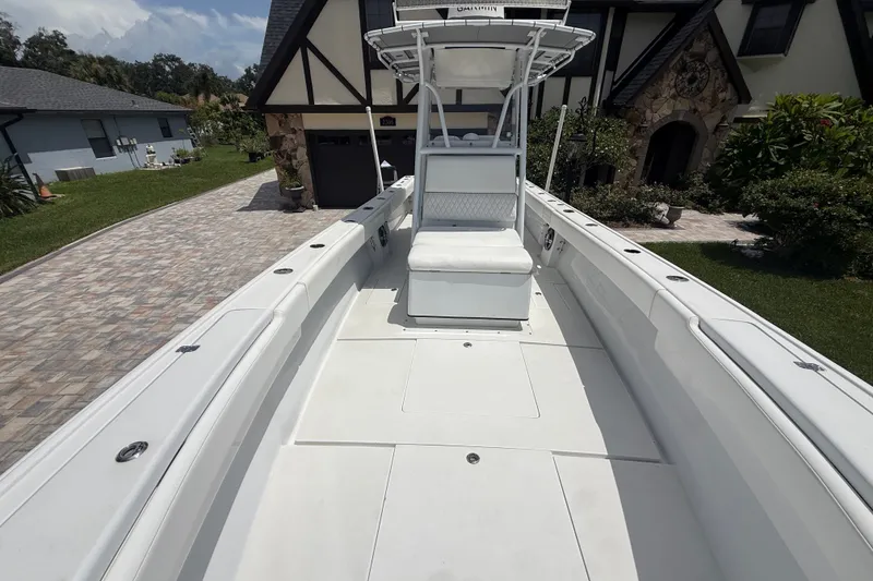 Slide: The Image of 1995 Intrepid 323 Open boat parked in a driveway, showcasing spacious deck and seating. - 48