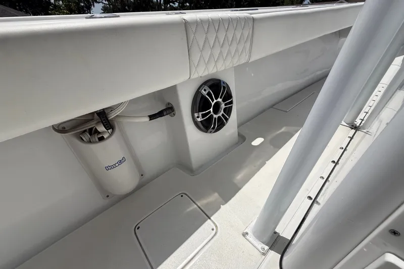 Slide: The Image of 1995 Intrepid 323 Open boat interior with speaker and hose storage. - 30