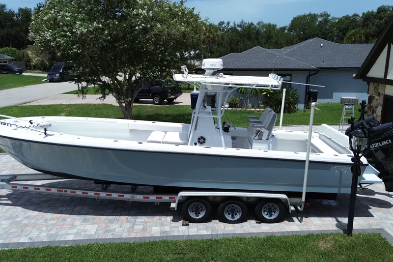 Slide: The Image of 1995 Intrepid 323 Open boat on trailer, parked in residential driveway. - 3