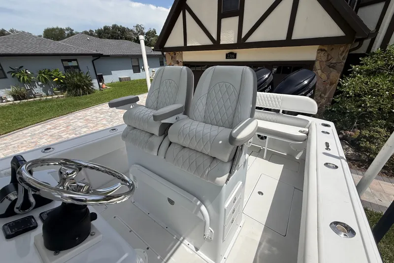 Slide: The Image of 1995 Intrepid 323 Open boat with dual seats and steering wheel, parked near a house. - 59