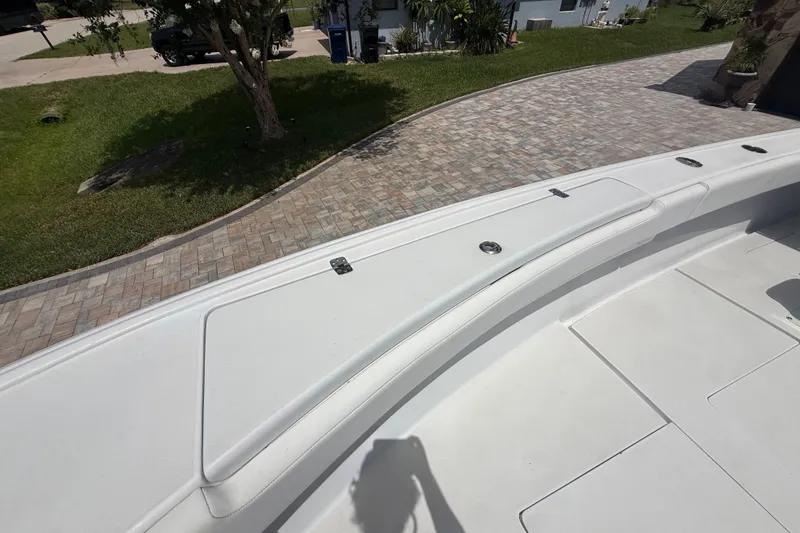 Slide: The Image of 1995 Intrepid 323 Open boat deck with storage compartments, parked on a paved driveway. - 44