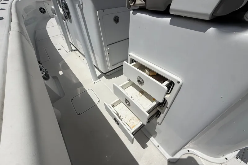 Slide: The Image of Interior view of a 1995 Intrepid 323 Open boat with open storage drawers. - 14