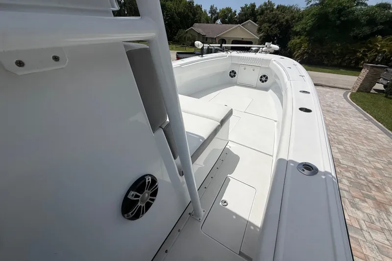 Slide: The Image of 1995 Intrepid 323 Open boat with spacious deck and seating, parked on a paved driveway. - 28