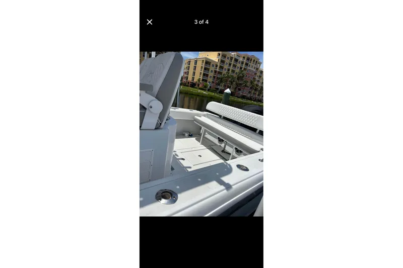 Slide: The Image of 1995 Intrepid 323 Open boat interior with seating, docked near waterfront buildings. - 6