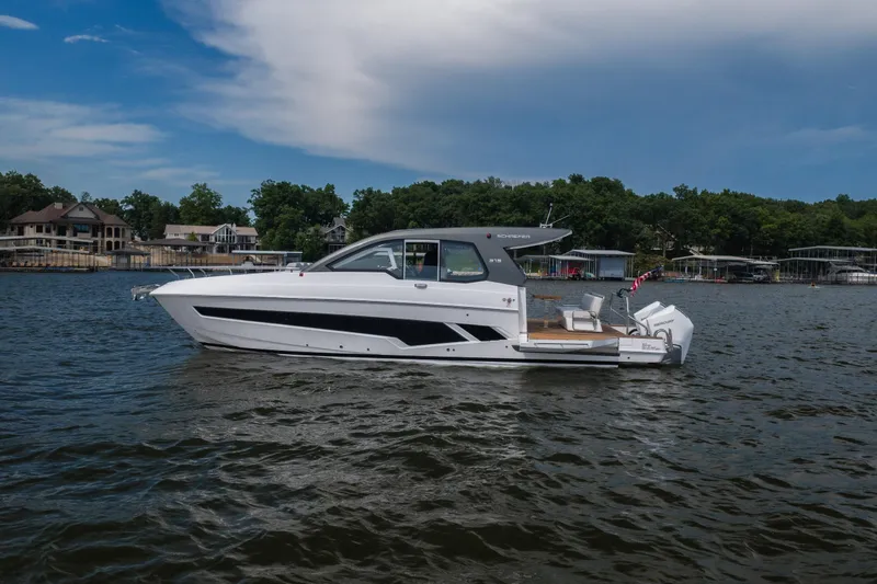 The Image of 2024 Schaefer 375 yacht cruising on a scenic lake with waterfront homes. - 1