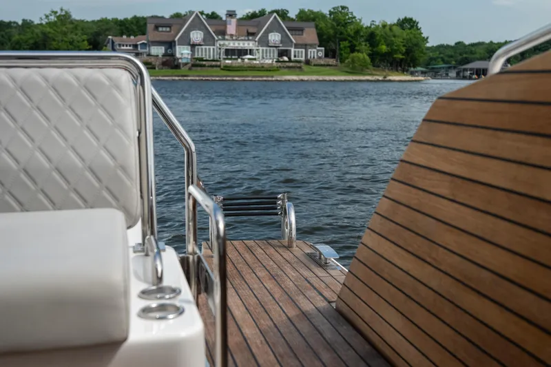 Slide: The Image of Luxury Schaefer 375 yacht deck overlooking serene waterfront estate, 2024 model. - 25