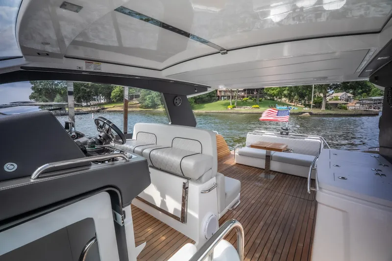 Slide: The Image of Luxurious 2024 Schaefer 375 yacht interior with seating, steering, and American flag on a lake. - 19