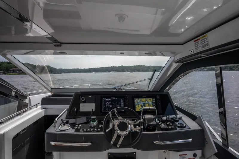 Slide: The Image of 2024 Schaefer 375 yacht cockpit with advanced navigation system on a serene lake. - 14