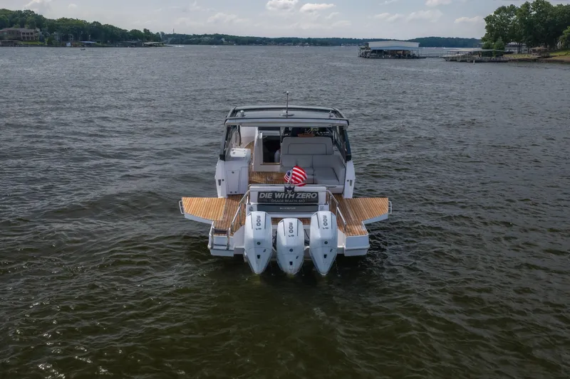 Slide: The Image of 2024 Schaefer 375 boat with triple engines on a lake, featuring a spacious deck. - 8