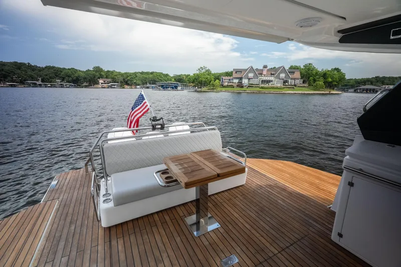 Slide: The Image of 2024 Schaefer 375 yacht deck with American flag, overlooking serene waterfront estate. - 29