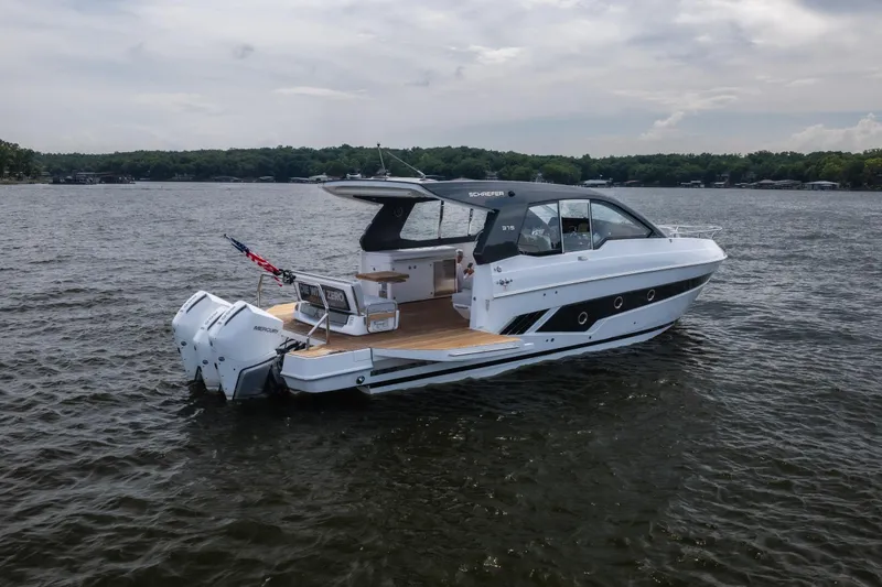 Slide: The Image of 2024 Schaefer 375 yacht on a lake, featuring sleek design and powerful Mercury engines. - 6