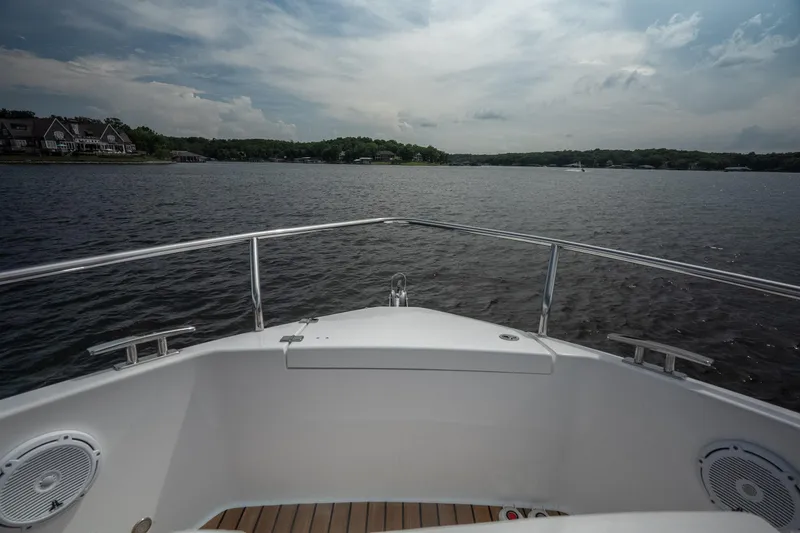 Slide: The Image of Bow view of 2024 Schaefer 375 yacht on a serene lake under cloudy skies. - 43