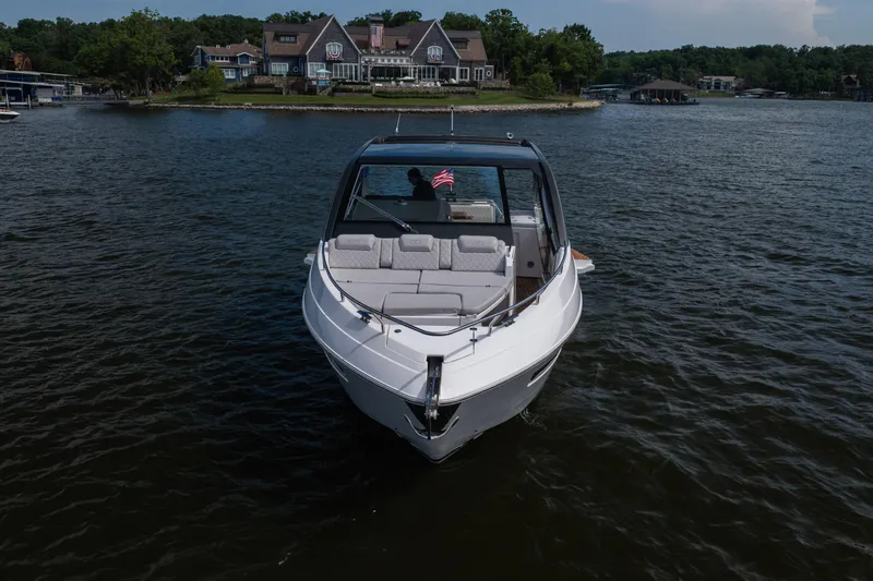 Slide: The Image of 2024 Schaefer 375 yacht on a serene lake near luxury waterfront homes. - 4