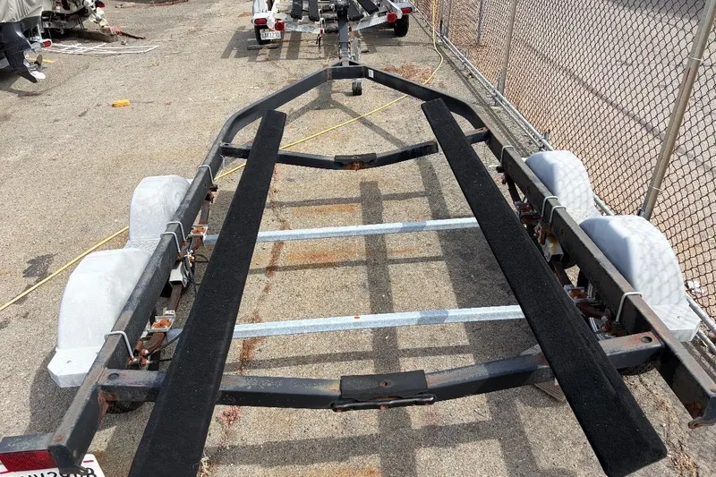 Slide: The Image of Boat trailer for 2021 Bayliner VR6 Bowrider I/O, parked on concrete near chain-link fence. - 18