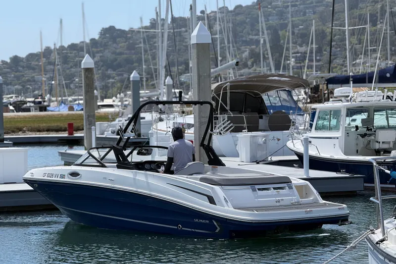 Slide: The Image of 2021 Bayliner VR5 Bowrider I/O docked at a marina with scenic background. - 6