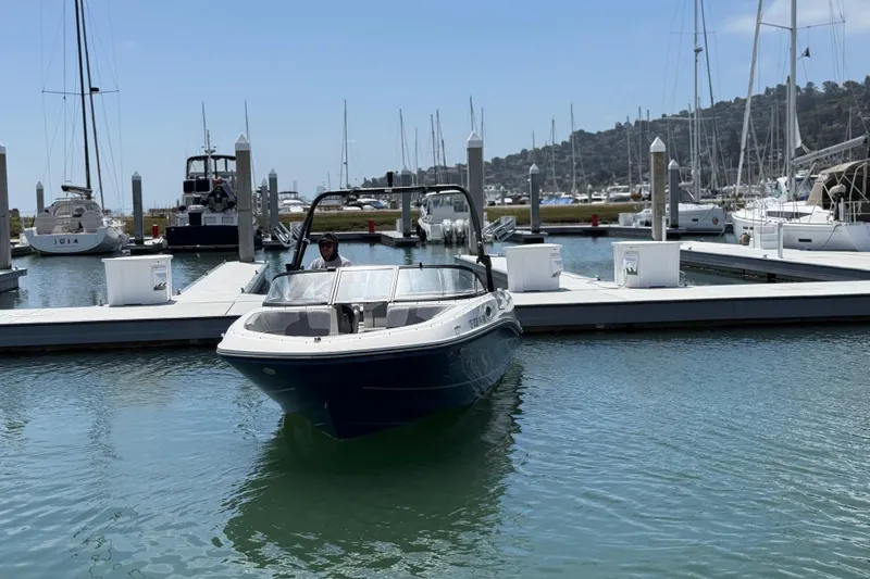 Slide: The Image of 2021 Bayliner VR5 Bowrider I/O docked at a marina with sailboats in the background. - 2