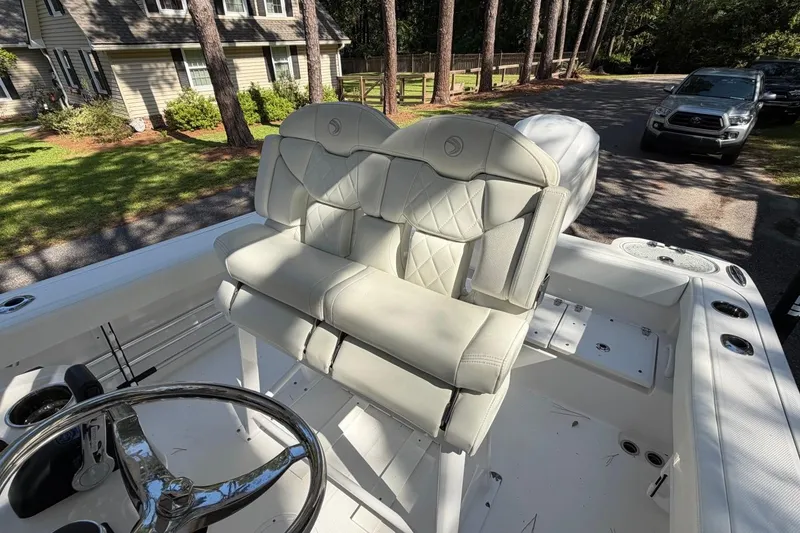 Slide: The Image of 2019 Edgewater 230CC boat interior with dual cushioned seats and steering wheel. - 23