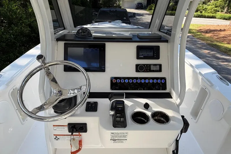 Slide: The Image of 2019 Edgewater 230CC boat dashboard with steering wheel, controls, and navigation equipment. - 17