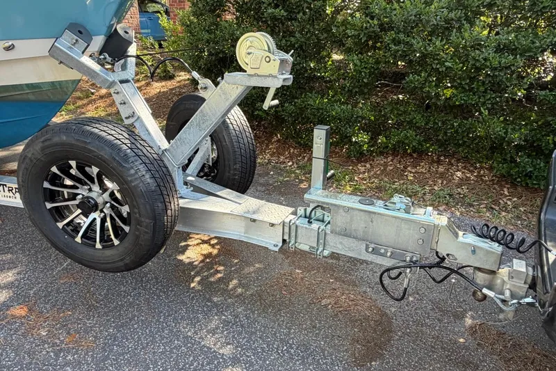 Slide: The Image of Trailer hitch and wheels of a 2019 Edgewater 230CC boat on a paved surface. - 5