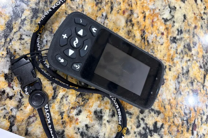 Slide: The Image of Remote control device on a granite countertop, featuring a lanyard with "Minn Kota" branding. - 34
