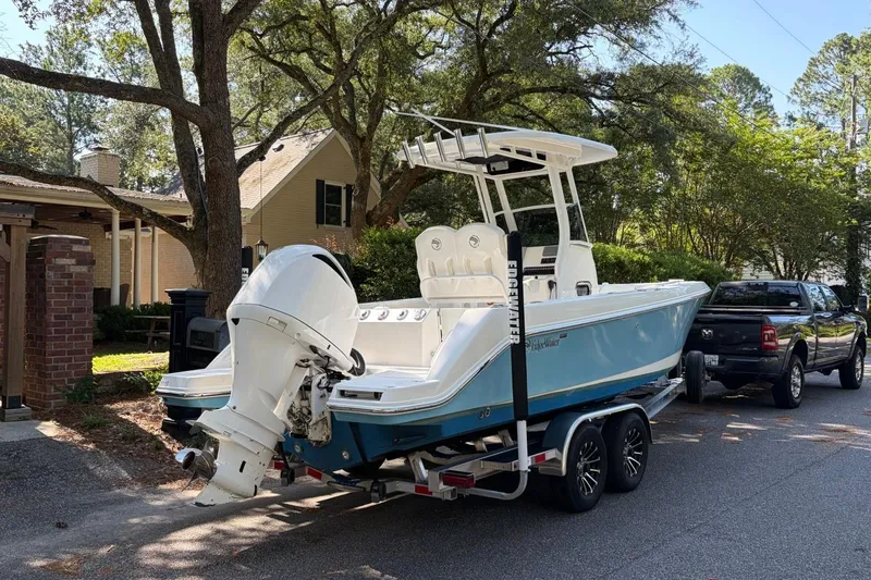 Slide: The Image of 2019 Edgewater 230CC boat on trailer, parked on a residential street. - 3
