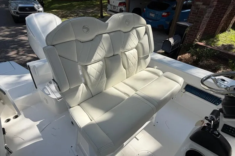 Slide: The Image of 2019 Edgewater 230CC boat interior with white cushioned seating and steering wheel. - 24