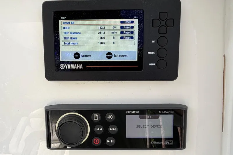 Slide: The Image of Yamaha and Fusion displays on 2019 Edgewater 230CC boat dashboard, showing trip data and audio controls. - 18