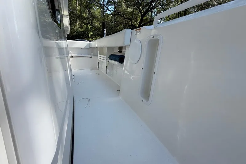 Slide: The Image of 2019 Edgewater 230CC boat interior, featuring spacious white deck and storage compartments. - 14