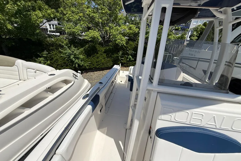 Slide: The Image of 2018 Robalo R222 Explorer boat deck with seating, surrounded by lush greenery. - 18