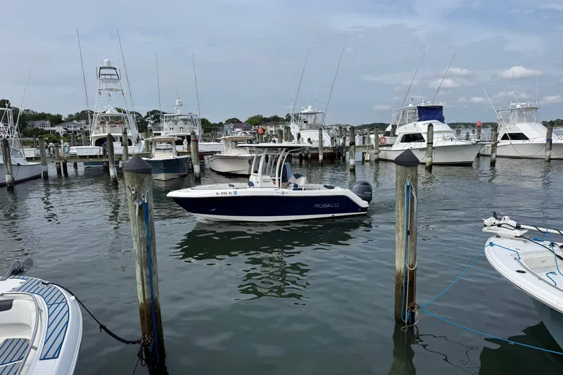 Slide: The Image of 2018 Robalo R222 Explorer boat docked in a marina with other vessels. - 3