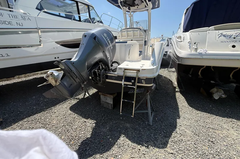 Slide: The Image of 2018 Robalo R222 Explorer boat with Yamaha outboard motor, docked between other boats. - 20