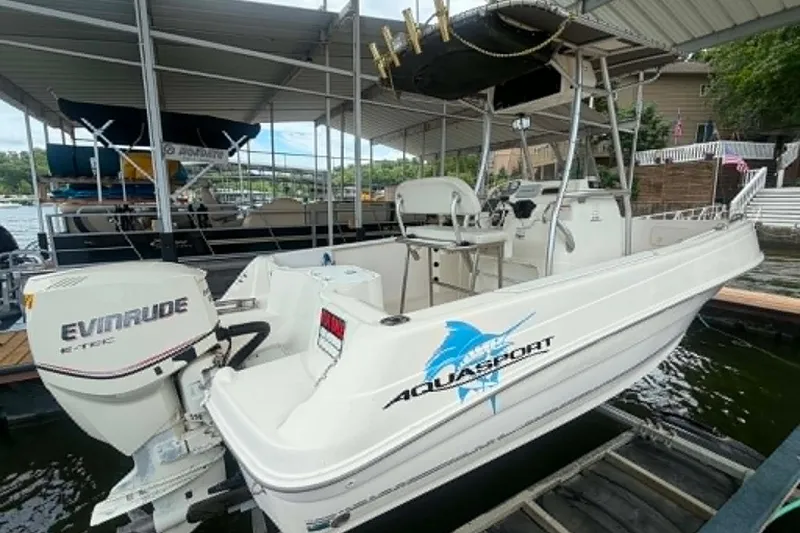Slide: The Image of 2005 Aquasport 2100 Center Console boat with Evinrude engine docked at marina. - 2