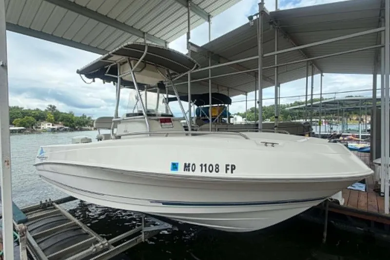 Slide: The Image of 2005 Aquasport 2100 Center Console boat docked under a covered marina. - 4