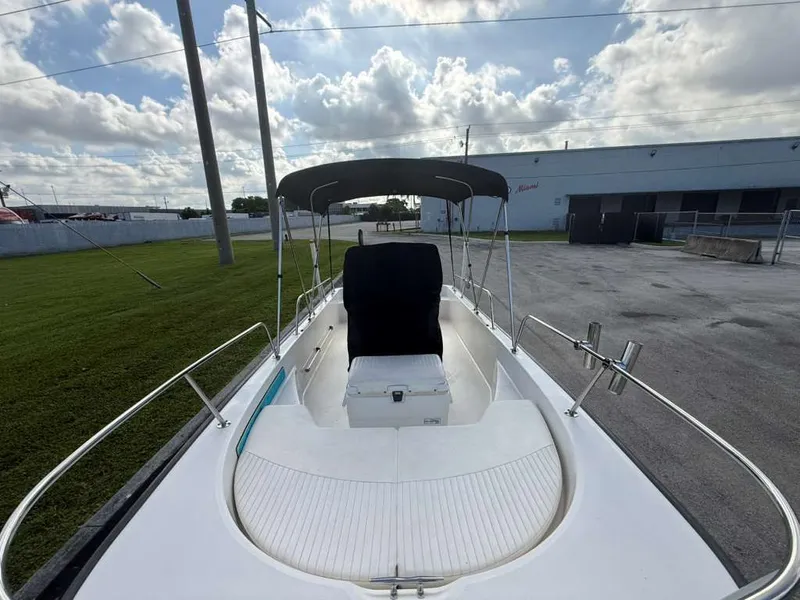 Slide: The Image of A 2016 Boston Whaler 170 Montauk with a Bimini top, parked on a lot. - 7