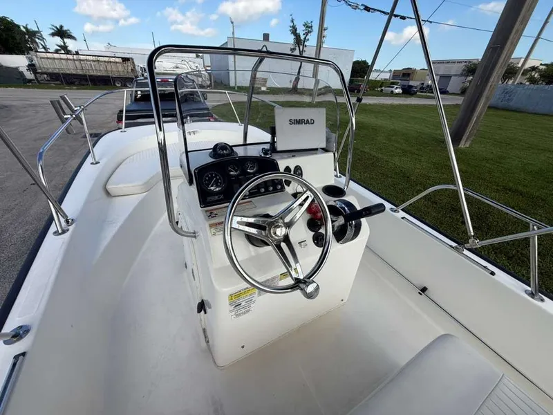 Slide: The Image of The image shows the cockpit of a 2016 Boston Whaler 170 Montauk. It features a steering wheel, gauges, and a Simrad unit. - 5