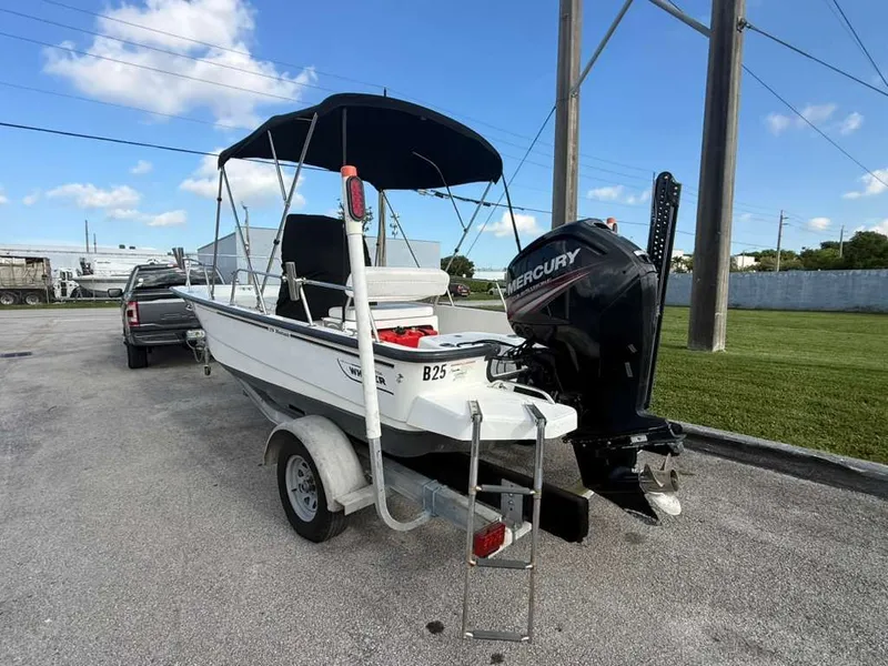 Slide: The Image of A 2016 Boston Whaler 170 Montauk on a trailer, featuring a Mercury outboard motor. - 11