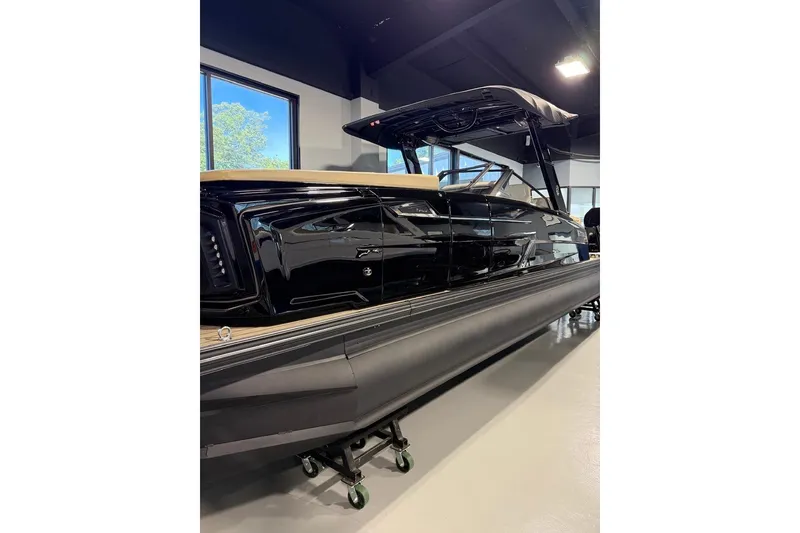 Slide: The Image of 2026 Balise Halo 26C Twin boat displayed indoors, showcasing sleek black design. - 2