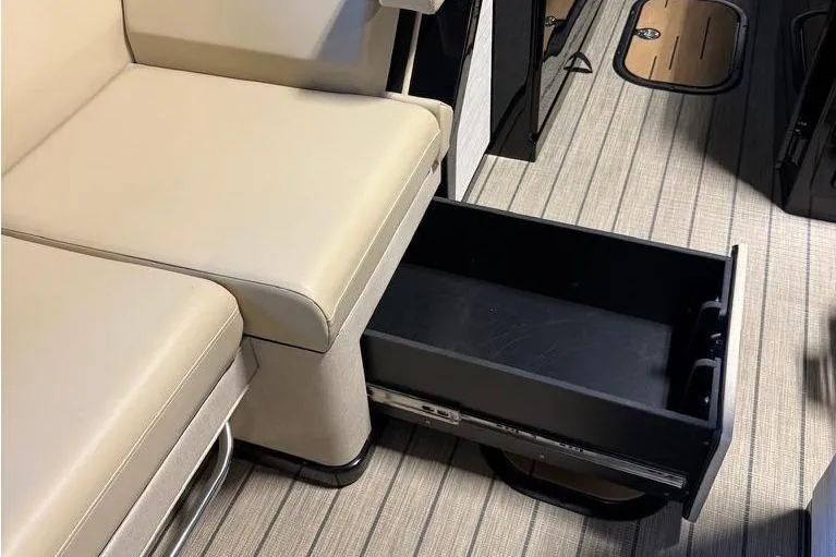 Slide: The Image of Interior of 2026 Balise Halo 26C Twin with beige seating and open storage drawer. - 24
