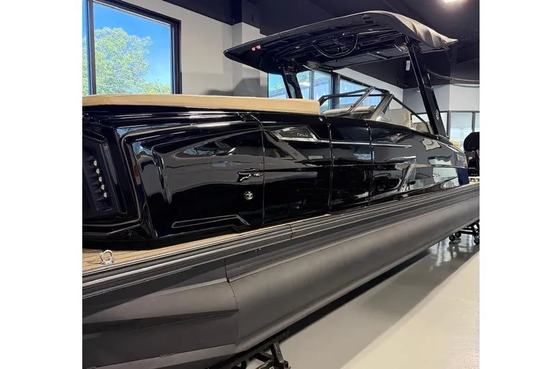 Slide: The Image of 2026 Balise Halo 26C Twin boat displayed indoors, showcasing sleek black design. - 28
