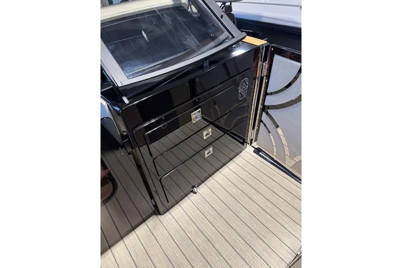 Slide: The Image of Sleek black cabinetry on the 2026 Balise Halo 26C Twin boat deck. - 13