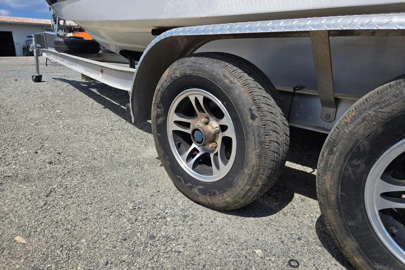 Slide: The Image of Trailer wheels of a 2000 Cobalt 246 boat on gravel surface. - 36