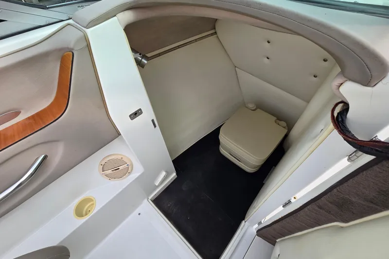 Slide: The Image of Interior of a 2000 Cobalt 246 boat featuring a compact restroom area. - 27