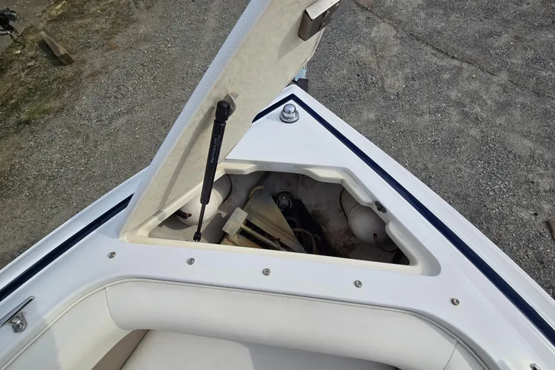 Slide: The Image of Open storage compartment on a 2000 Cobalt 246 boat, showing anchor and equipment. - 23