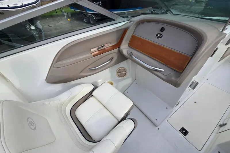 Slide: The Image of Interior of a 2000 Cobalt 246 boat, featuring white seating and sleek dashboard design. - 16