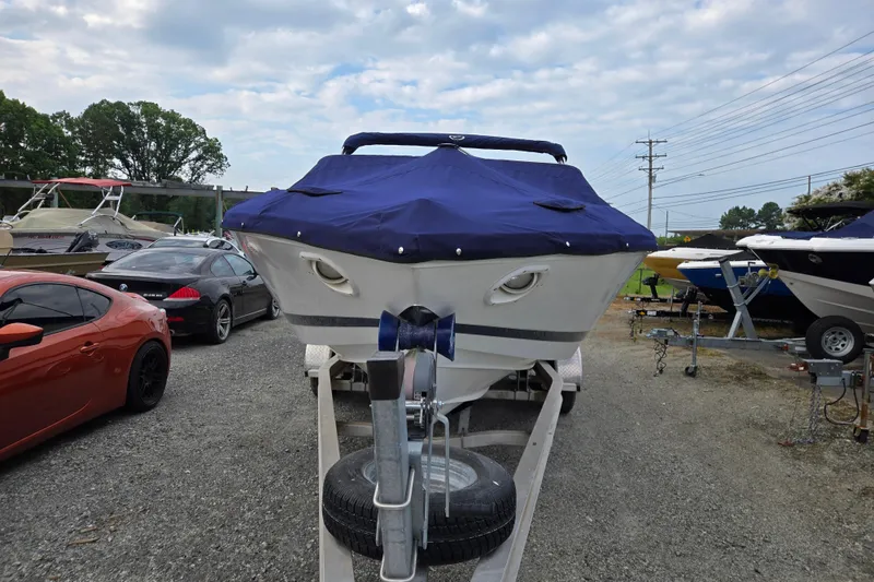 Slide: The Image of Covered 2000 Cobalt 246 boat on trailer, surrounded by parked cars and other boats. - 1